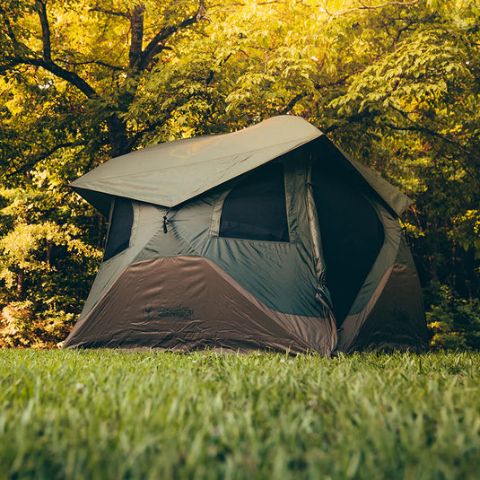 Gazelle Tents T4 Hub Tent Overland Edition set up in a lush forest clearing with trees showcasing autumn foliage.