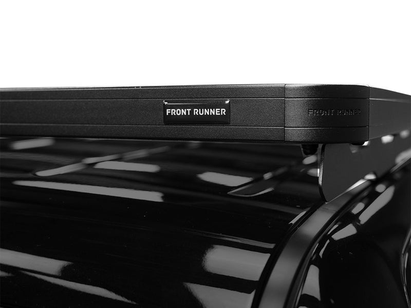 Load image into Gallery viewer, Close-up of Front Runner Slimline II Roof Rack Kit low profile with logo on black Dodge Ram Crew Cab 2009-Current model.