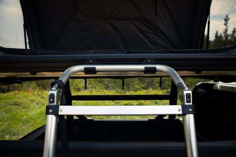 Load image into Gallery viewer, Close-up of the Freespirit Recreation Odyssey Series Black Top Hard Shell Rooftop Tent showing the durable ladder and mounting system.
