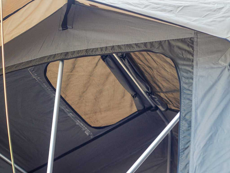 Load image into Gallery viewer, Close-up view of a Front Runner Roof Top Tent with open window showing durable fabric and sturdy frame.
