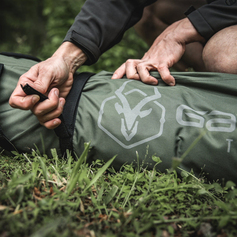 Load image into Gallery viewer, Close-up of hands setting up a Gazelle Tents T4 Hub Tent with logo visible on fabric.

