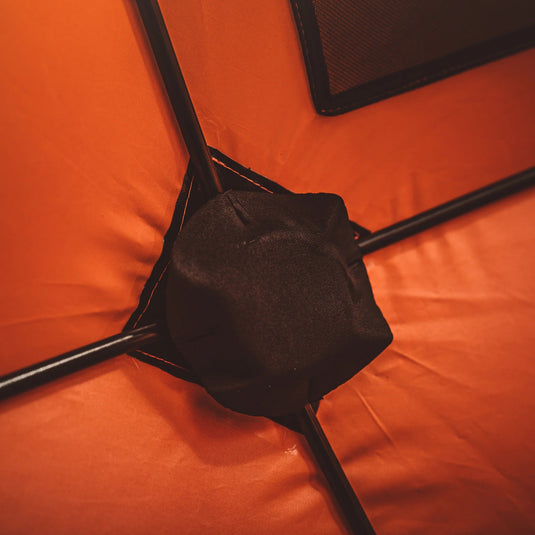 Close-up view of Gazelle Tents T4 Hub Tent hub mechanism with orange fabric and black supports.