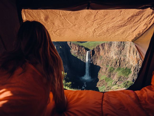 Load image into Gallery viewer, Woman enjoying scenic view from inside a Front Runner Roof Top Tent overlooking a waterfall
