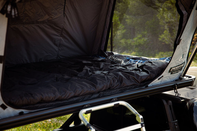 Load image into Gallery viewer, Interior view of Freespirit Recreation Odyssey Series black top hard shell rooftop tent on a vehicle with open window panels.
