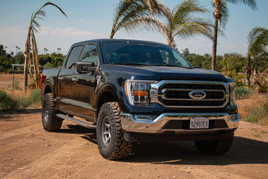 Black Ford truck with ICON Vehicle Dynamics Rebound PRO satin black wheels parked outdoors.