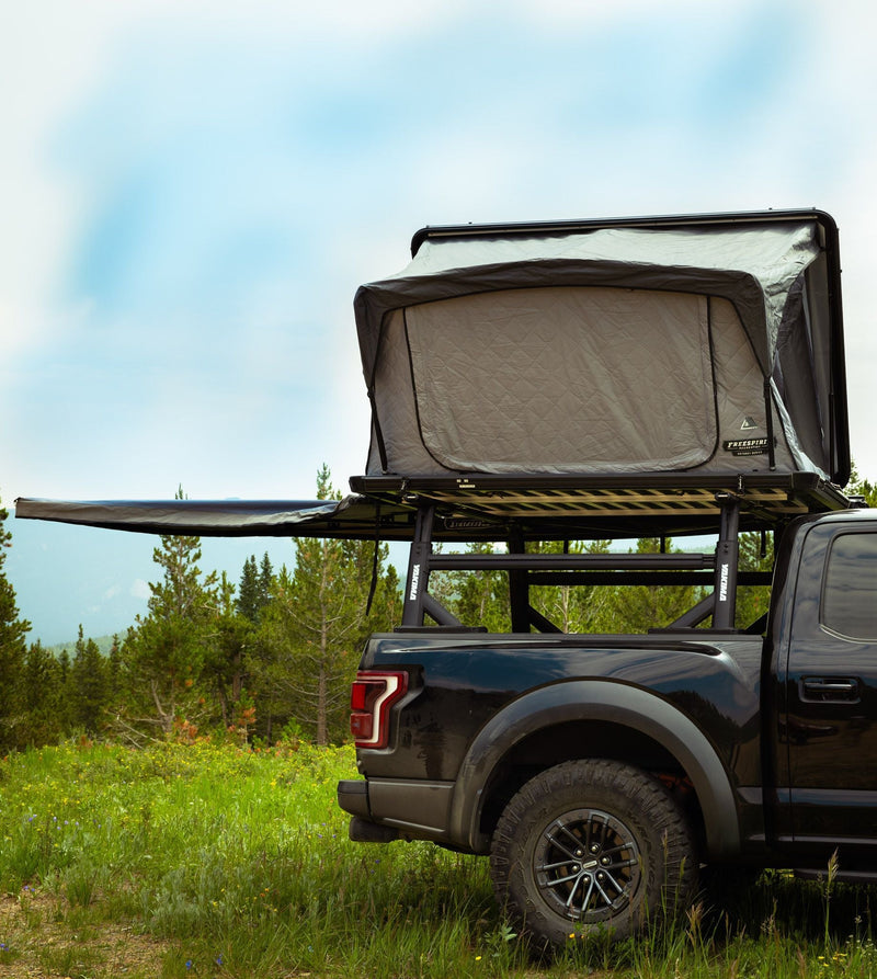 Load image into Gallery viewer, Freespirit Recreation Odyssey Series Black Top Hard Shell Rooftop Tent mounted on truck in natural setting.
