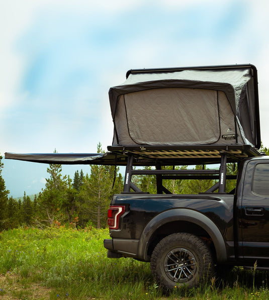 Freespirit Recreation Odyssey Series Black Top Hard Shell Rooftop Tent mounted on truck in natural setting.