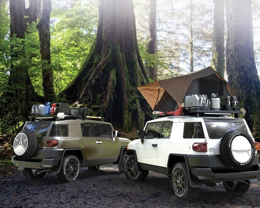Toyota FJ Cruisers equipped with Front Runner Slimline II 1/2 Roof Rack Kits, showcasing their outdoor off-road capabilities in a forest setting.