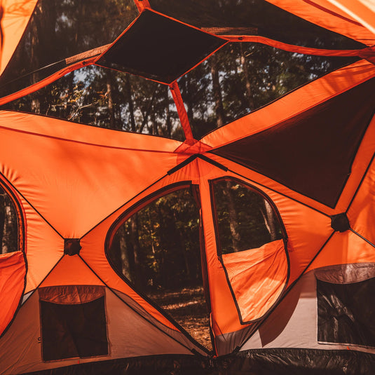Orange Gazelle T4 Hub Tent setup in forest with open windows showing spacious interior design