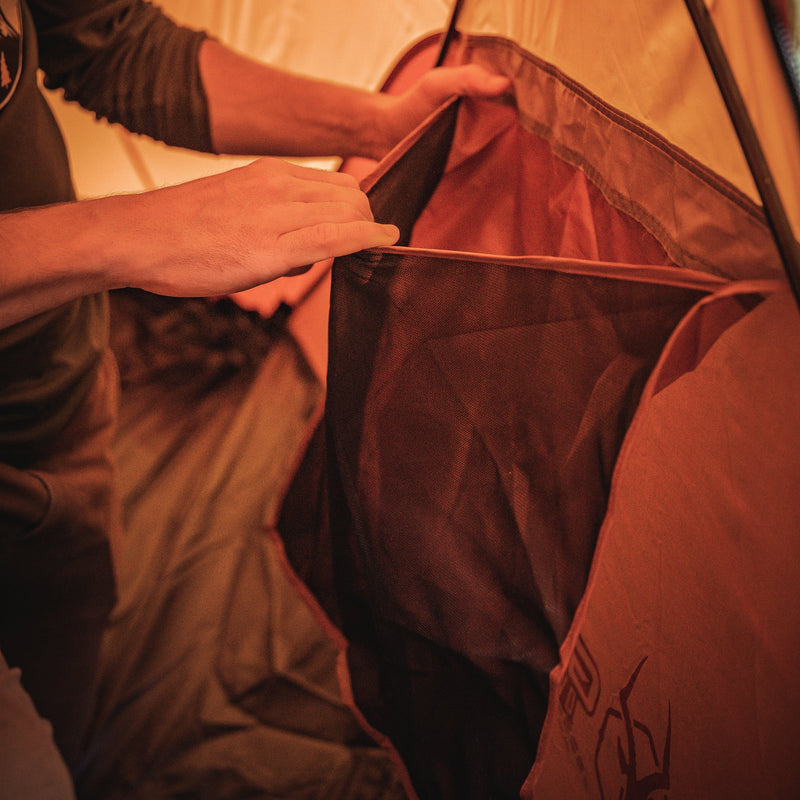 Load image into Gallery viewer, Person setting up the interior of Gazelle Tents T4 Hub Tent Overland Edition with focus on the durable fabric and spacious design.
