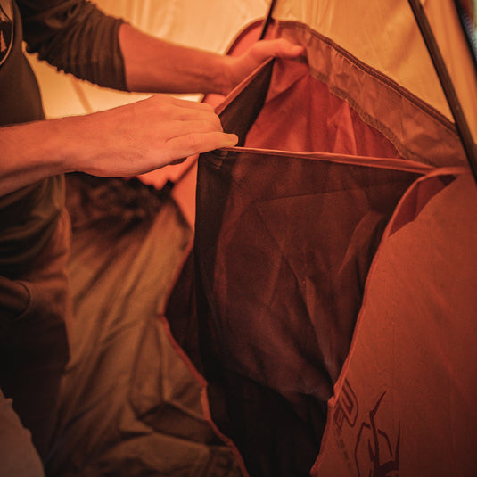 Person setting up the interior of Gazelle Tents T4 Hub Tent Overland Edition with focus on the durable fabric and spacious design.