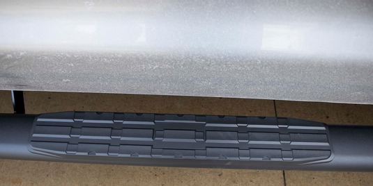 Alt text: "Close-up view of Fishbone Offroad 2007-2021 Toyota Tundra Double Cab 5 Inch Oval Side Step, featuring the textured step surface for grip."