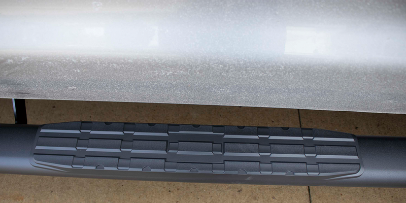 Load image into Gallery viewer, Alt text: &quot;Close-up view of Fishbone Offroad 5 Inch Oval Side Step installed on Toyota Tundra Crew Max Cab, showcasing the non-slip patterned surface.&quot;
