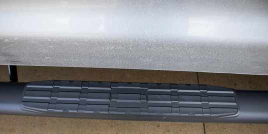 Alt text: "Close-up view of Fishbone Offroad 5 Inch Oval Side Step installed on Toyota Tundra Crew Max Cab, showcasing the non-slip patterned surface."