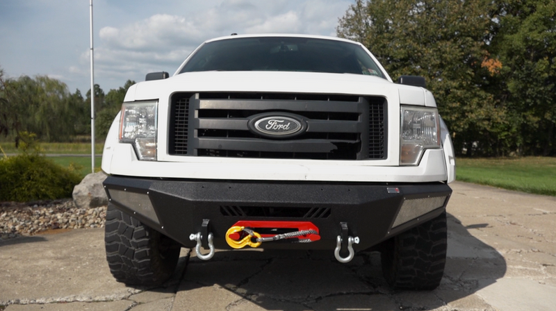 Load image into Gallery viewer, Alt text: White 2009-2014 Ford F-150 equipped with black Fishbone Offroad Pelican Front Bumper, featuring integrated winch and tow hooks.
