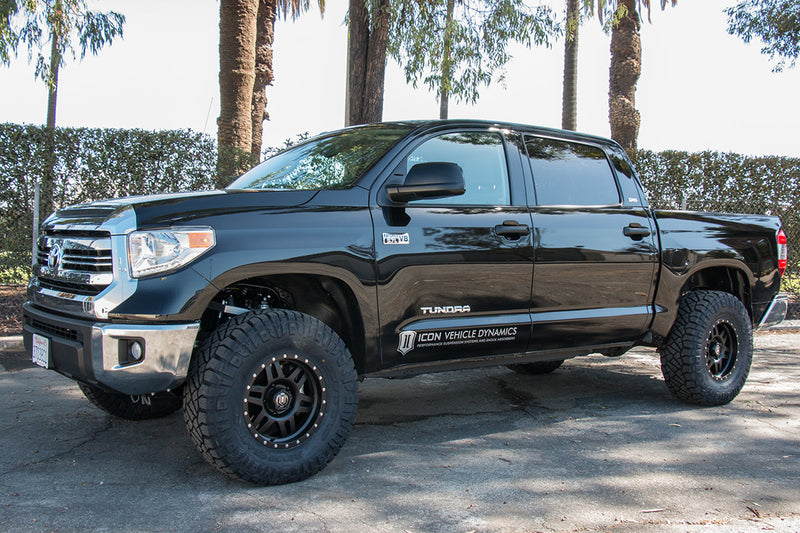 Load image into Gallery viewer, Black Toyota Tundra fitted with ICON Vehicle Dynamics Six Speed Gunmetal Wheels with Black Ring parked outdoors.

