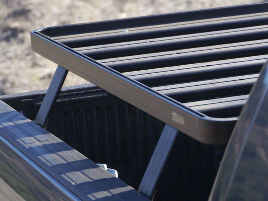 Close-up of a Front Runner GMC Canyon Slimline II Load Bed Rack installed on a pickup truck, showcasing the sturdy aluminum construction and sleek design suitable for 2004-current models.