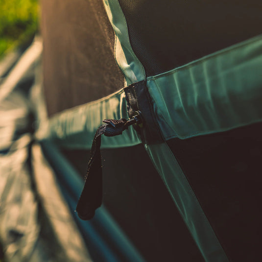Close-up view of a Gazelle Tents G6 6-Sided Portable Gazebo with Wind Panel, highlighting the durable fabric and secure tie-down detail.