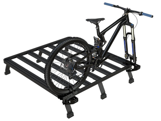 Front Runner Load Bed Rack Side Mount with a mounted mountain bike, showcasing the sturdy design and compatibility with bicycle transport.