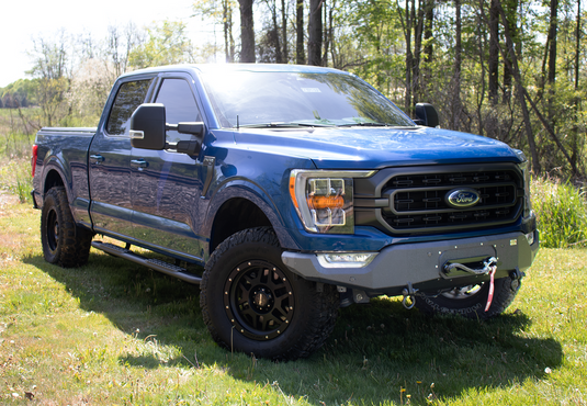 Blue Ford F-150 with Fishbone Offroad Winch Plate on Pelican Front Bumper parked outdoors