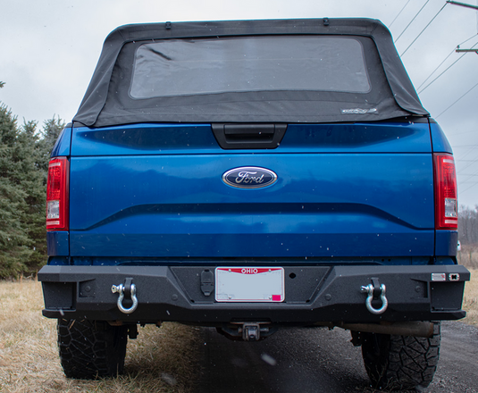 Alt text: "2015 Ford F-150 with Fishbone Offroad Pelican Rear Bumper upgrade, featuring tow hooks and rugged design."