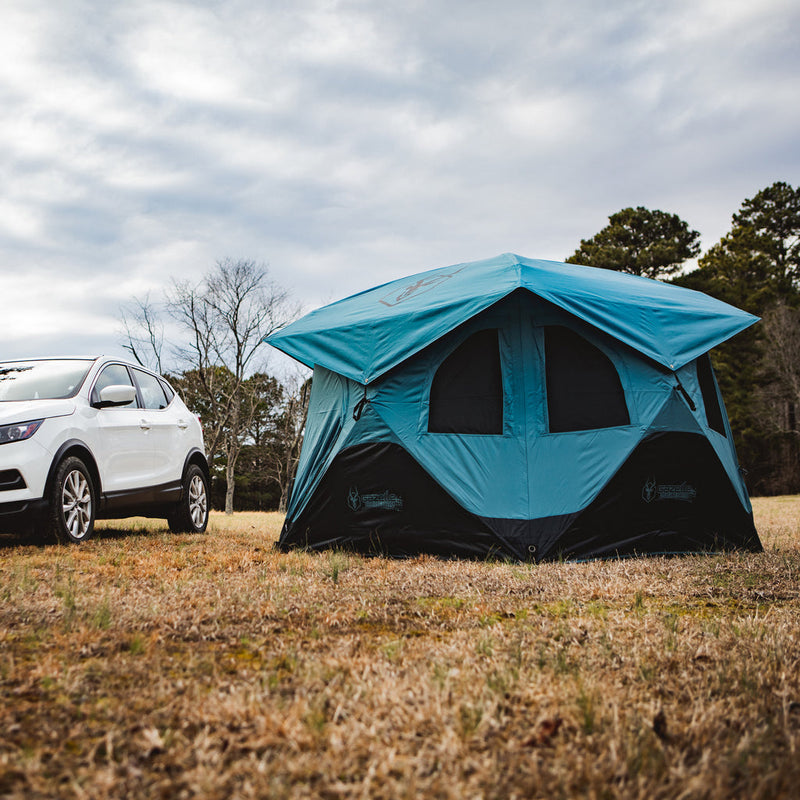 Load image into Gallery viewer, Alt text: &quot;Gazelle Tents T3X Overland Edition Tent set up in a field with a white SUV parked beside it, showcasing the tent’s spacious design suitable for car camping and outdoor adventures.&quot;
