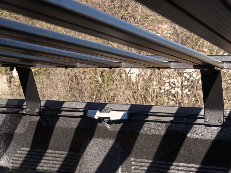 Load image into Gallery viewer, Close-up of the Front Runner Slimline II Load Bed Rack Kit installed on a Toyota Tundra Crew Max Truck, highlighting the durable construction and secure mounting system.
