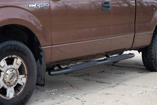Alt text: "Fishbone Offroad oval side steps installed on a 2009-2014 Ford F-150 Extended Super Cab, providing durable and stylish entry assistance."