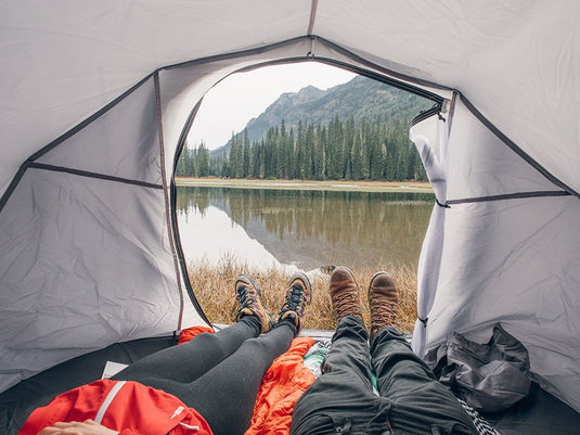 "View from inside Front Runner Flip Pop Tent overlooking serene lake and mountains with two people relaxing"
