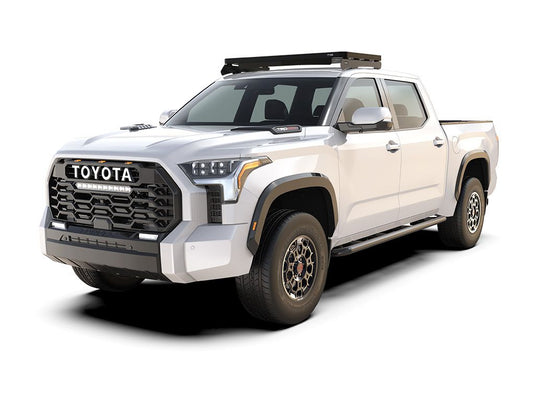 Alt text: "White Toyota Tundra 3rd Gen with Front Runner Cab Over Camper Slimline II Roof Rack Kit installed, isolated on a white background."