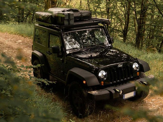 Black Jeep Wrangler JK 2 door with Front Runner Extreme Roof Rack Kit driving through forest.