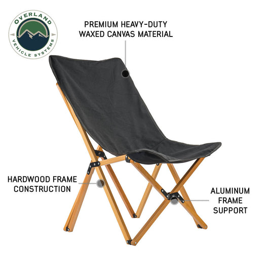 Alt text: "Overland Vehicle Systems Kick It Camp Chair with wood base and storage bag, featuring premium heavy-duty waxed canvas material and hardwood frame construction with aluminum support."