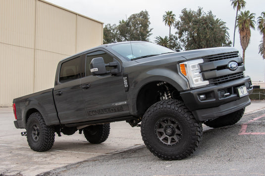 Black Ford F-150 fitted with ICON Vehicle Dynamics Rebound HD satin black wheels parked outdoors.