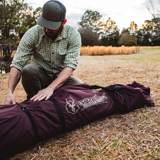 Man unpacking Gazelle Tents T-Hex Hub Tent Overland Edition from carrying bag on grass.