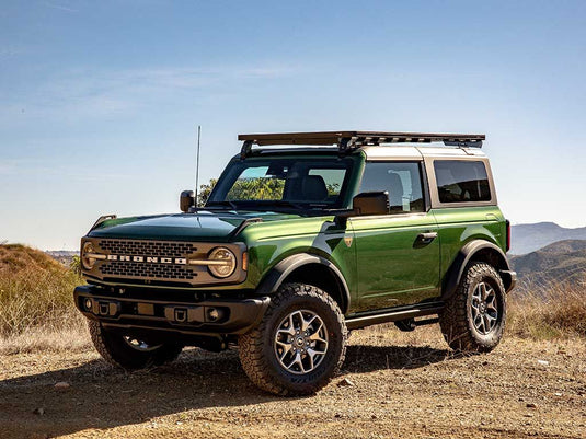 Green 2022 Ford Bronco 2 Door with a Slimline II Roof Rack Kit by Front Runner parked outdoors.