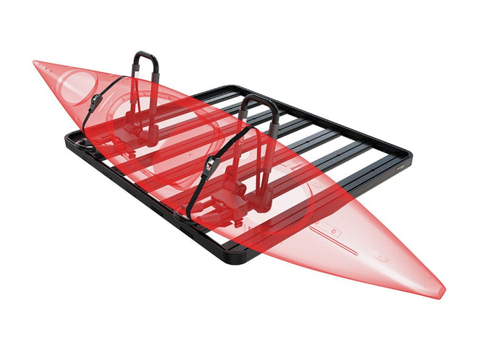 Red kayak secured on a black foldable J-style Front Runner kayak carrier mounted on vehicle roof rack.