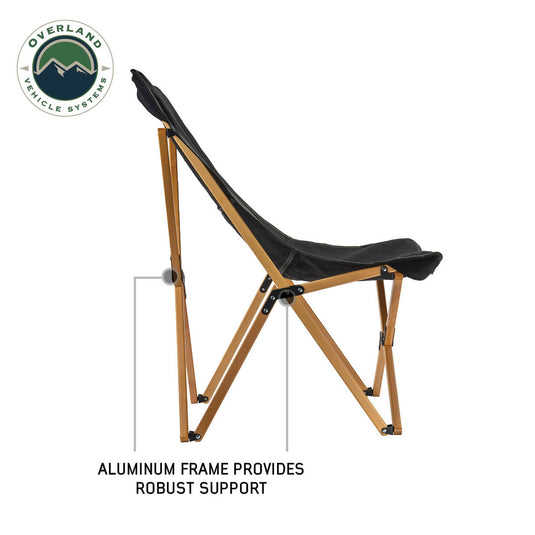 Alt text: "Overland Vehicle Systems Kick It Camp Chair with wood base, black seat, and storage bag, featuring an aluminum frame for robust support."