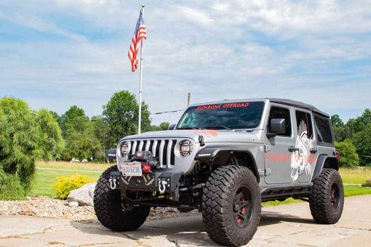 Alt text: "Jeep Wrangler equipped with Fishbone Offroad Barracuda Modular Bumper, showcased outdoors with Fishbone decals, suitable for model years 2007-Current JK, JKU, JL, JLU & Gladiator JT."