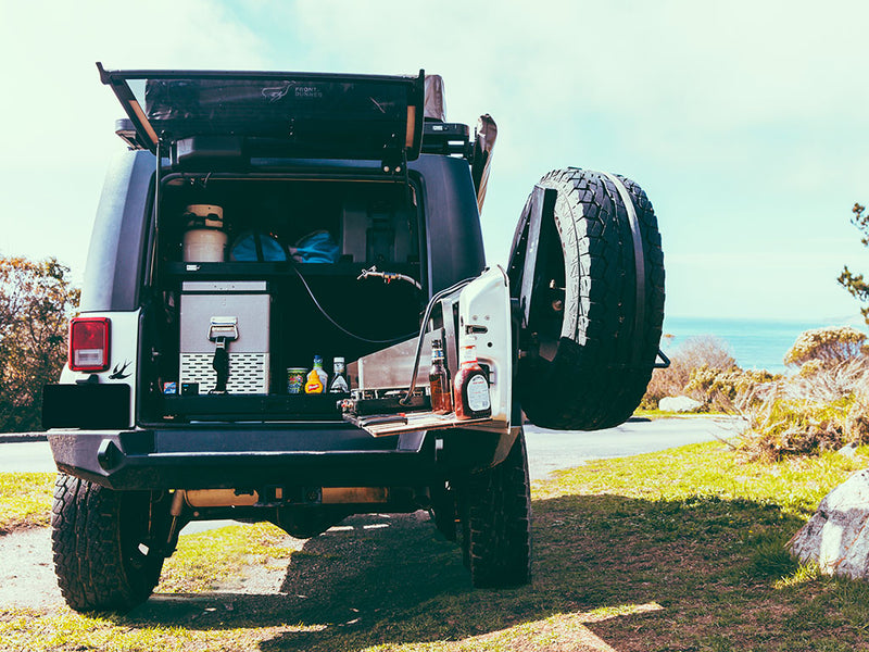 Load image into Gallery viewer, Front Runner Jeep Wrangler JKU 4-Door Cargo Storage Interior Rack installed in the trunk, showcasing storage solutions while parked outdoors.
