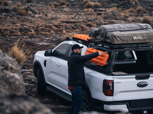 "Man loading gear onto Front Runner Pro Bed Rack on Ford Ranger T6.2 Wildtrak Double Cab"