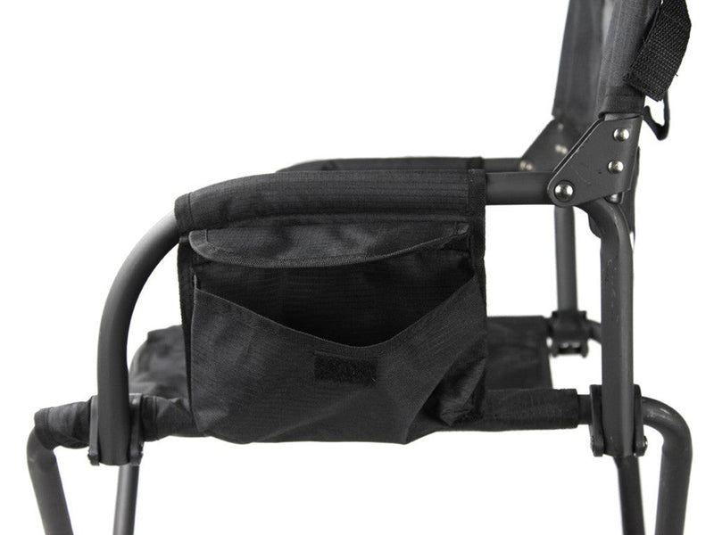 Load image into Gallery viewer, Close-up of black Front Runner Expander Camping Chair showing the seating area, armrest, and storage pocket detail.
