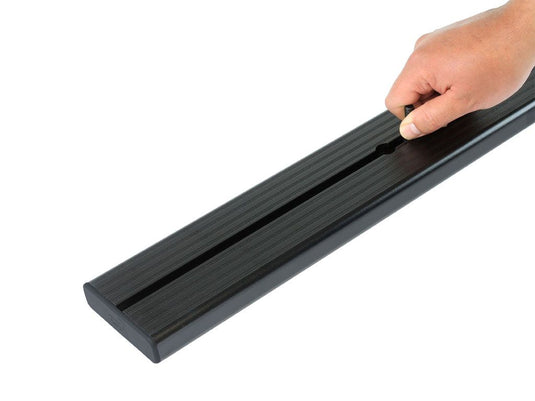 Hand holding a Front Runner Load Bar for Chevrolet Silverado Crew Cab, suitable for models from 2007 to present