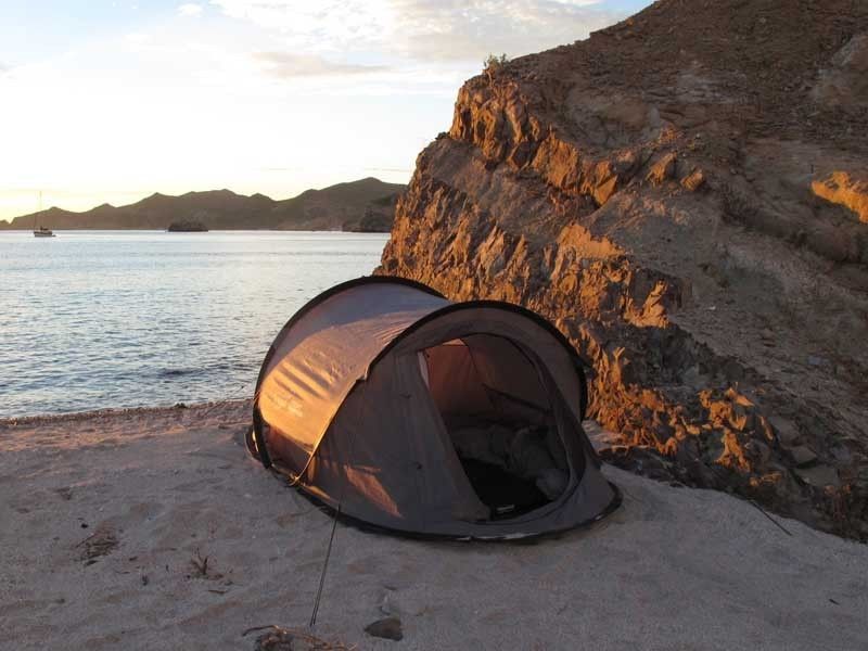 Load image into Gallery viewer, &quot;Front Runner Flip Pop Tent set up on a beach at sunset with calm sea and mountains in the background.&quot;

