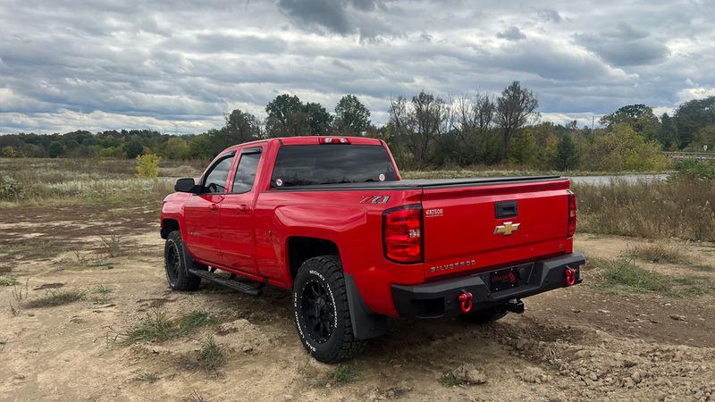 Load image into Gallery viewer, Red Chevrolet Silverado Double Cab with Fishbone Offroad 5-Inch Oval Side Steps installed, parked outdoors.
