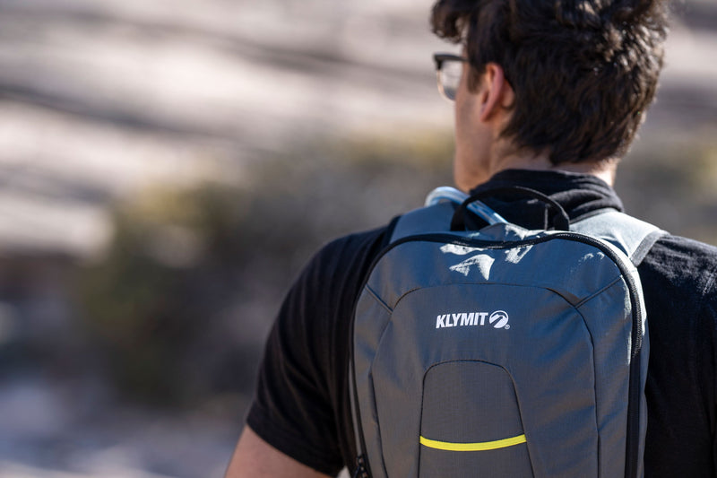 Load image into Gallery viewer, Person wearing Klymit Echo 12L Hydration Pack outdoors
