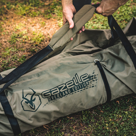 Person holding a Gazelle Tents T3 Tandem Water-Resistant Duffle Bag in outdoor setting