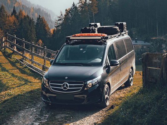 Mercedes van equipped with Front Runner Recovery Device Mounting Kit, roof rack and off-road gear parked in a scenic forest