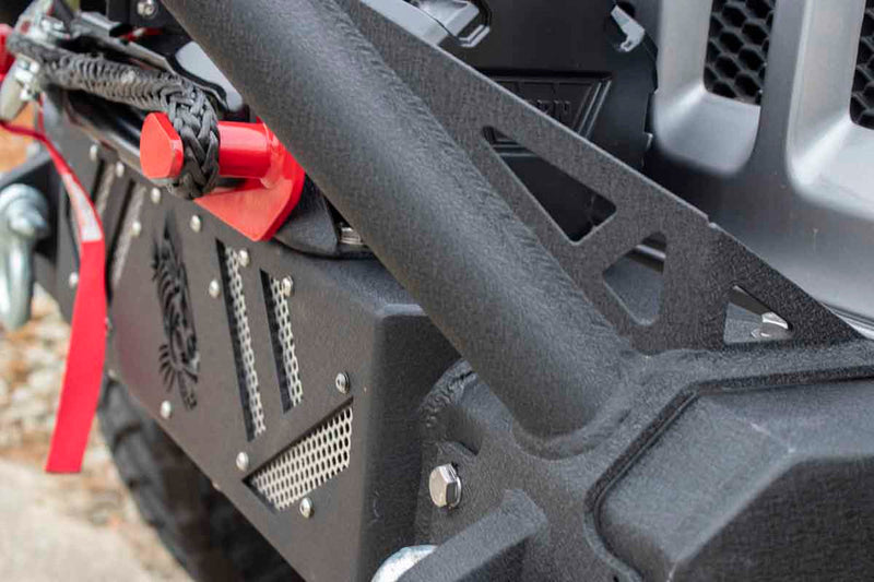 Load image into Gallery viewer, Alt text: &quot;Close-up of a Fishbone Offroad Barracuda Modular Bumper on a Jeep Wrangler, featuring textured surfaces and integrated winch mount.&quot;
