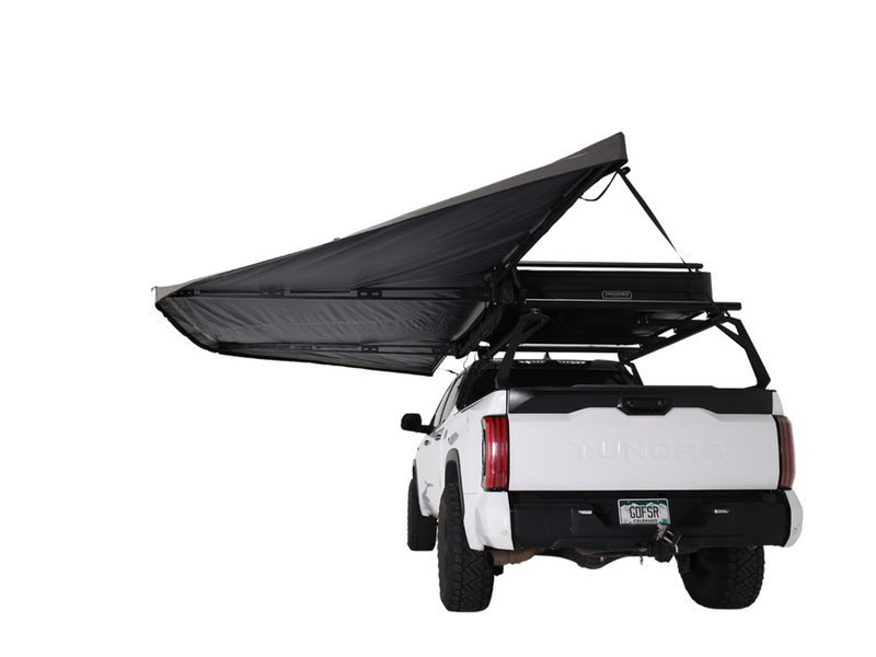 Load image into Gallery viewer, Alt text: &quot;White pickup truck with a Freespirit Recreation 180 Degree Awning fully extended, mounted on a roof rack, providing shade and shelter.&quot;
