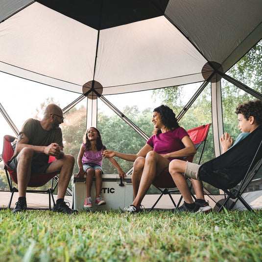 Family enjoying outdoor camping with Territory Tents 6-Sided Screen Tent, spacious and bug-free.